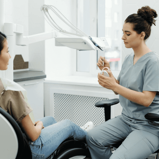 A woman consults with a dentist while seated, highlighting the role of a Dental Virtual Receptionist in patient care.