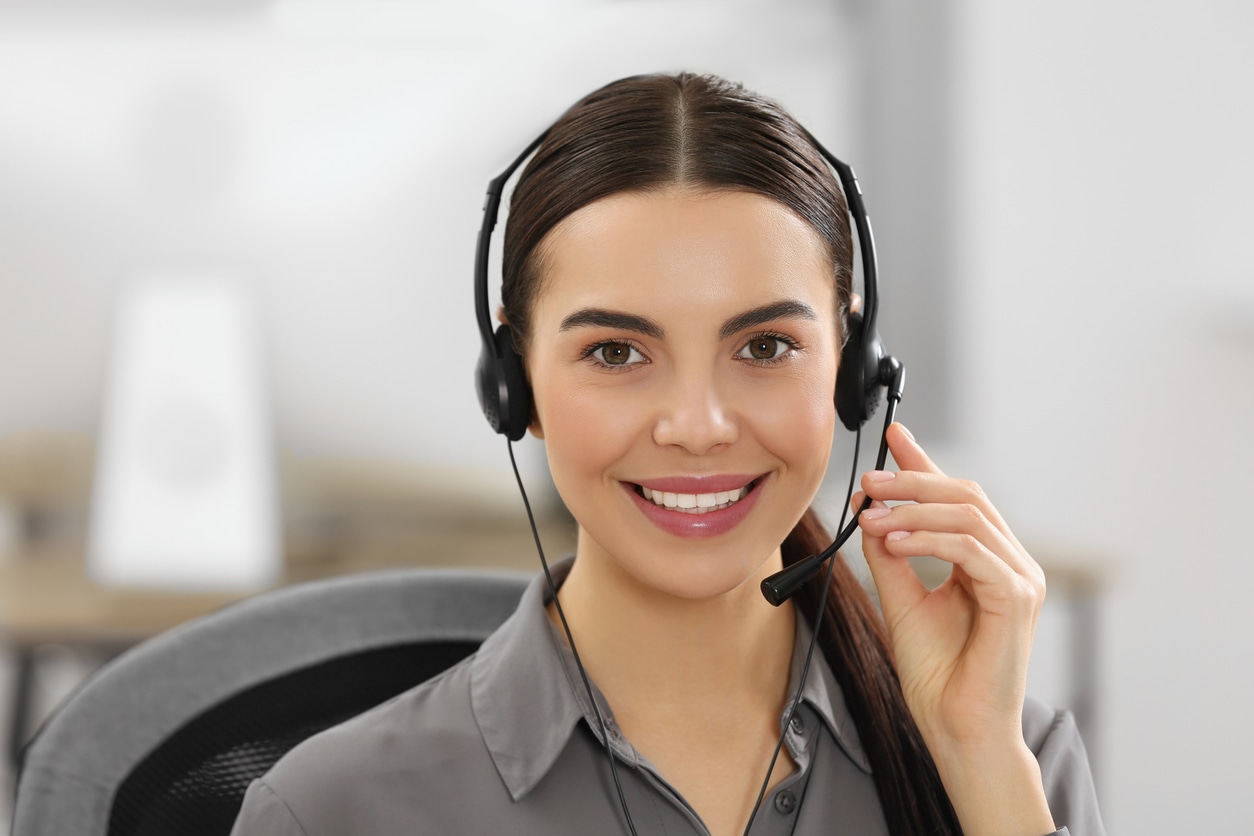 A woman in an office wearing a headset, representing the After Hours Answering Service for professional communication.